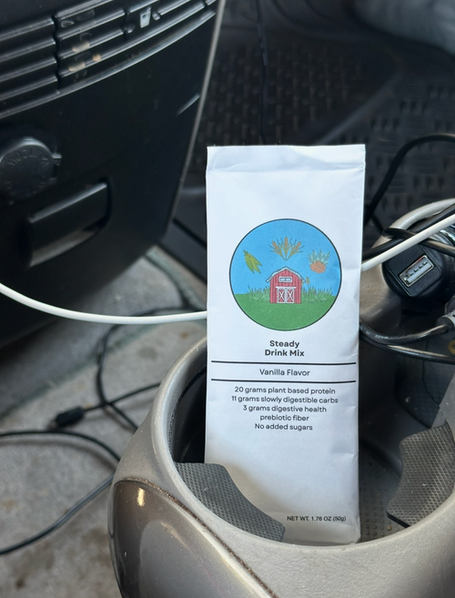 A white bag of Steady Brews Mix coffee sits in a car cup holder 